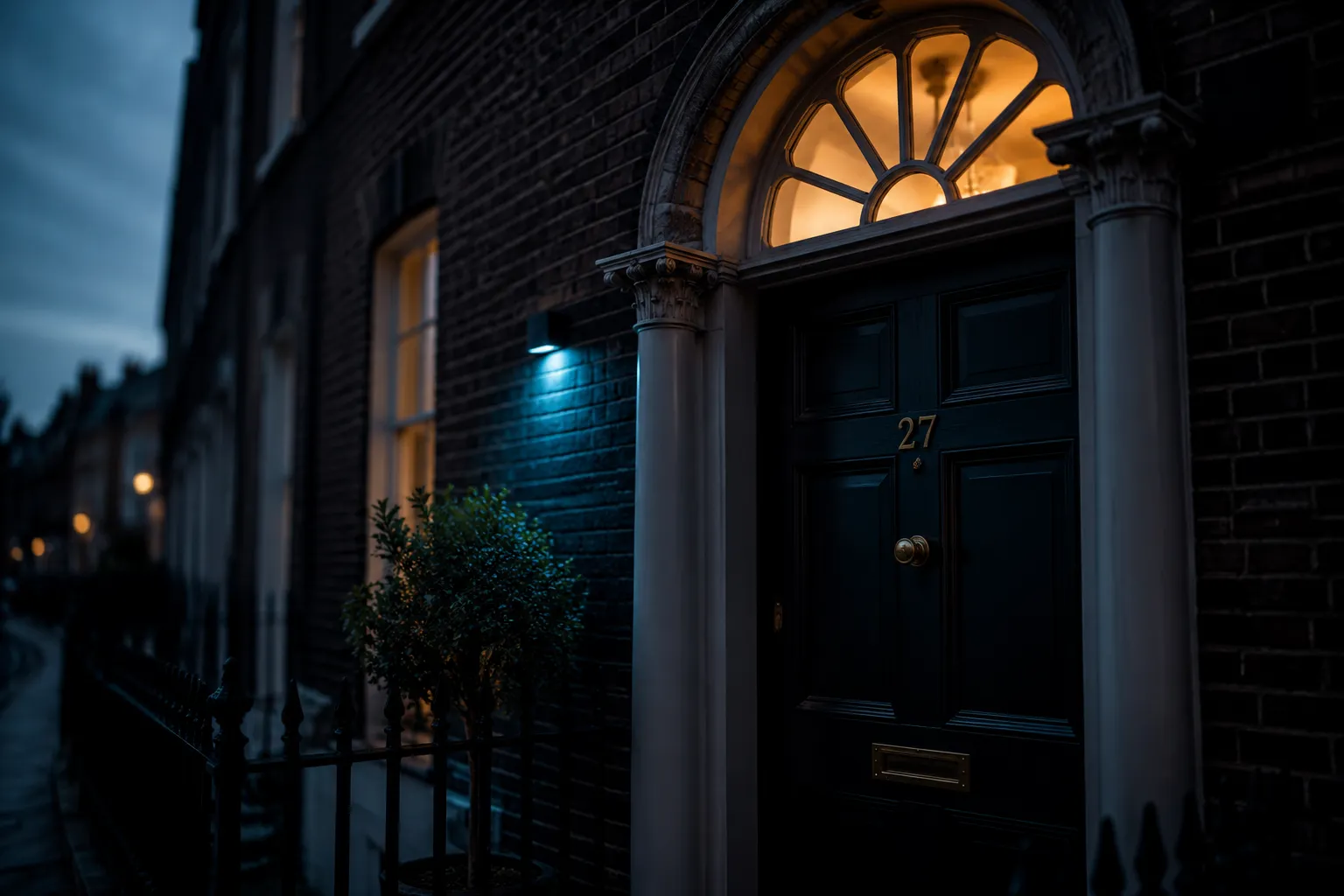 The lit doorway of a period terraced property at dusk, fresh on the market